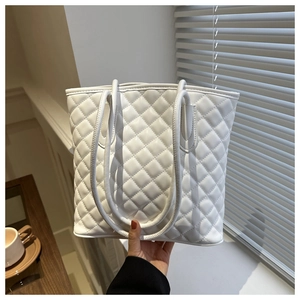 Detailed view of the white quilted tote bag featuring elegant diamond lattice stitching