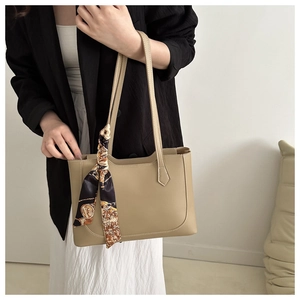Detail of beige tote bag with vintage printed scarf on model in classic casual outfit