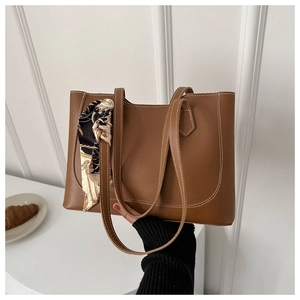 Brown tote bag detail with white contrast stitching and decorative vintage silk scarf handle