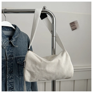 Close-up of off-white corduroy tote bag with fashion label on metal hanger