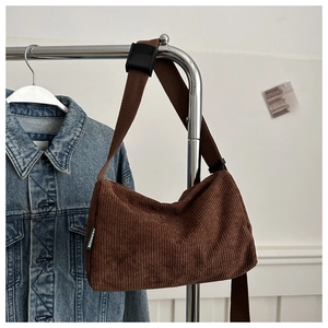 Detailed close-up of dark brown corduroy texture and adjustable shoulder strap buckle