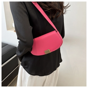 Magenta semi-circular PU leather handbag worn by model against a white wall background