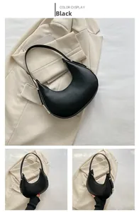 Detail view of a minimalist black leather hobo bag with a silver metal adjustable buckle