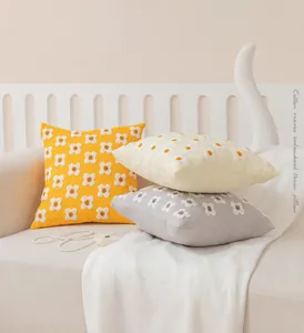 Détail de la broderie de marguerites sur des housses de coussin en coton de 12oz