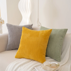 Minimalist corduroy throw pillow covers in yellow, grey and green on a white sofa