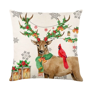 Christmas reindeer pillow cover with holly leaves and red cardinal on ivory linen background