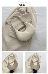 Close-up of white crescent hobo bag with smooth texture and sleek metal zipper detail