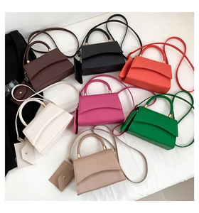 Flat lay of multiple colorful mini handbags with textured finishes and shoulder straps