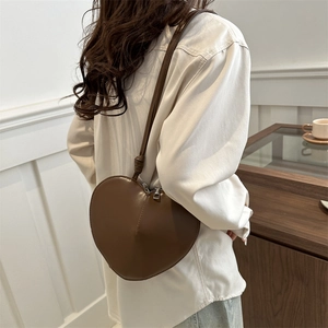 Sac bandoulière en forme de cœur marron en similicuir lisse présenté sur mannequin