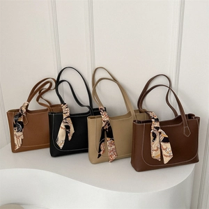 Chic tote bags with bow scarves in four colors on a modern display stand