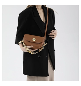 Brown leather saddle bag with decorative silk scarf gold chain handle and metal lock