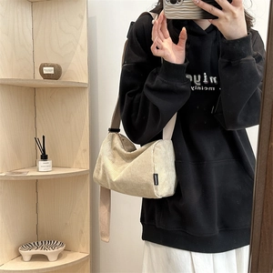 Beige corduroy crossbody tote bag with wide strap in a minimalist casual mirror selfie