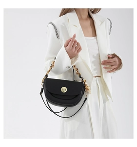 Detail of black semi-circle saddle bag with gold chain and silk scarf handle