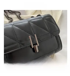 Close-up of quilted black leather texture and polished silver double bar metal lock