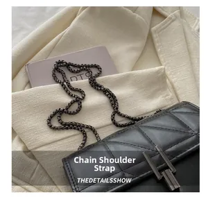 Close-up of quilted pattern and dark metal chain strap on a black luxury crossbody bag