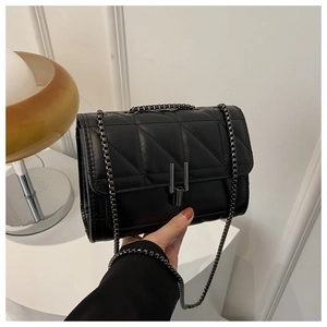 Détail du sac bandoulière noir matelassé avec chaîne en cuir de haute qualité