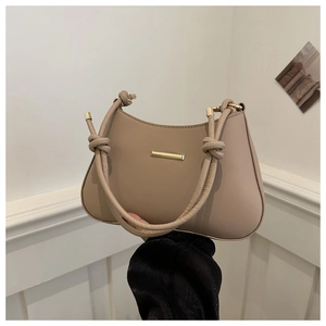 Chic beige half-moon hobo bag with unique knotted handle and gold metal detail