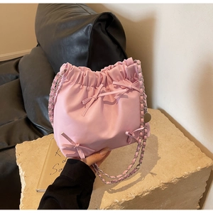 Detail of pink cloud bag showing delicate bow decorations and silver metal chain strap