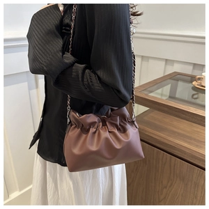 Brown PU leather pleated cloud bag with elegant metal chain strap worn by a model