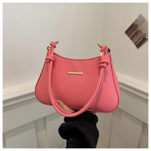 Pink minimalist faux leather underarm bag with gold accents and knotted strap design