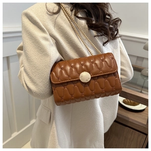 Detail der karamellbraunen Stepptasche mit Marmorschnalle an beigem Blazer-Outfit