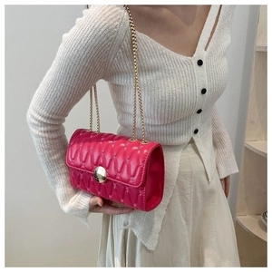 Détail du sac bandoulière matelassé rose avec fermoir doré rond et chaîne fine