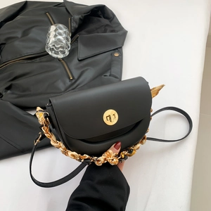Sleek black saddle bag with golden lock and silk-wrapped chain strap for daily wear
