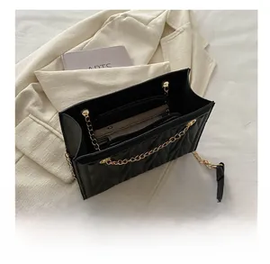 Top view of black quilted chain bag with multiple compartments and interior zipper