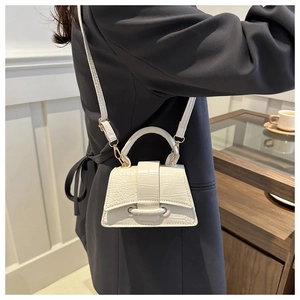White crocodile pattern handbag with hourglass curved base shown with shoulder strap