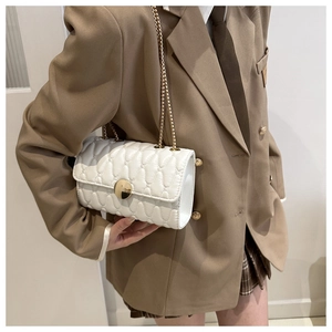 Detailansicht weiße Stepptasche mit goldener Kette und metallischem Klickverschluss