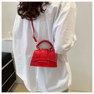 Detailed texture of red crocodile pattern on a minimalist fashion crossbody mini bag