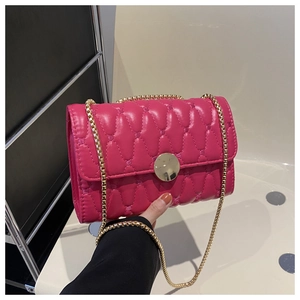 Détail du sac matelassé rouge rose en similicuir avec chaîne dorée et fermoir métal