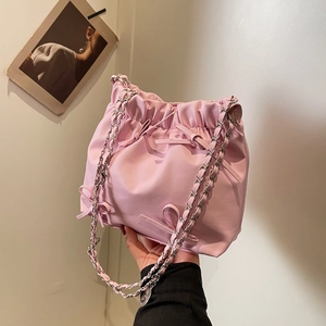 Pink drawstring bucket bag with decorative bows and metal chain shoulder strap for women