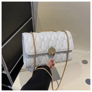 Détail du sac matelassé blanc avec surpiqûres et boucle ronde dorée chic