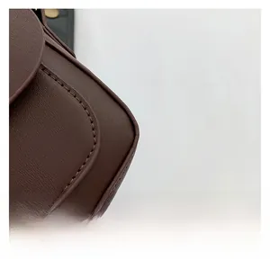 Close-up of the premium dark brown litchi pattern leather texture and neat stitching