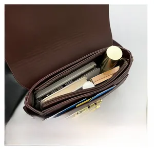 Detail of multi-compartment interior for brown crossbody bag with gold chain strap