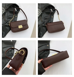 Detail view of dark coffee leather shoulder bag with golden clasp and chain strap