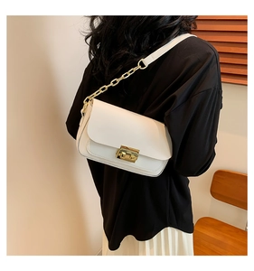 Detail of white leather shoulder bag with gold chain strap and metal lock clasp