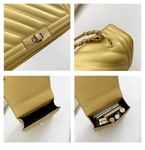 Detail view of gold quilted crossbody bag with metal lock and chain strap interior