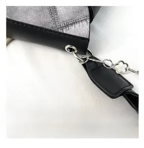 Detailed macro view of silver floral chain and hardware on a chic black leather handbag