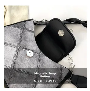 Detail of magnetic snap closure and denim print texture on a chic shoulder bag