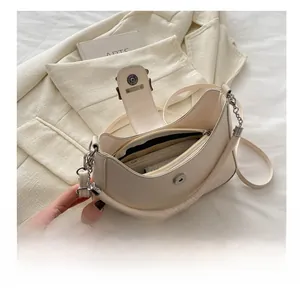 Dettaglio dell'interno della borsa in pelle color crema con vari scomparti e tasche