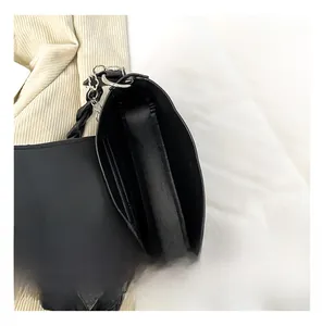 Top-down view of the interior compartment and pocket of the black shoulder bag