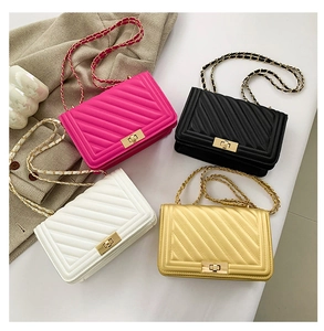 Flat lay of quilted crossbody bags in four colors with gold metal chain straps