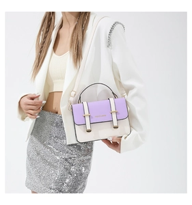 Detail of a purple and white crossbody bag with FASHION & BAGS text on a female model
