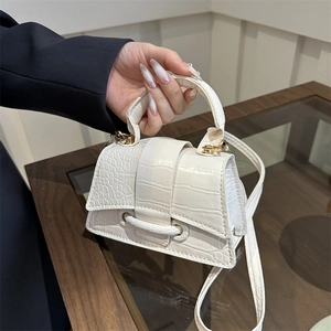 Chic white mini crossbody bag with crocodile embossing and golden hardware in hand