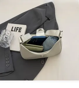 Spacious interior of minimalist cream bow shoulder bag holding umbrella and wallet