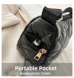 Détail de la poche zippée latérale sur un sac bandoulière matelassé noir et doré