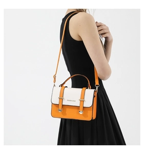 Detail of a chic orange and white contrast crossbody bag with a slim shoulder strap