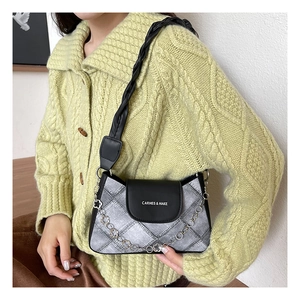 Detail of grey textured shoulder bag with silver heart chain and branded black flap